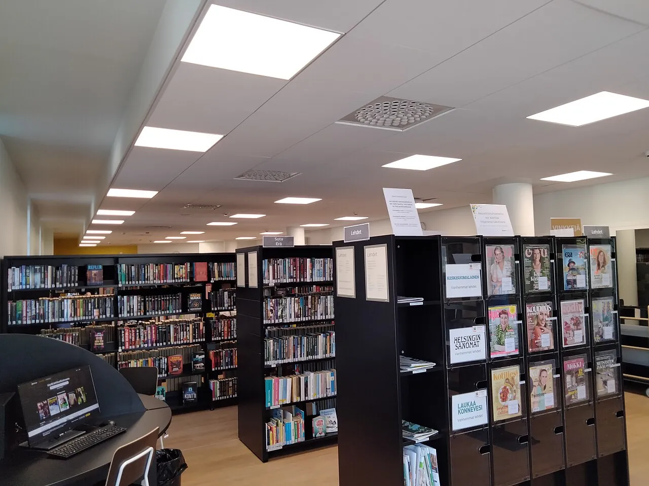 Bright library with rows of bookshelves and a computer desk
